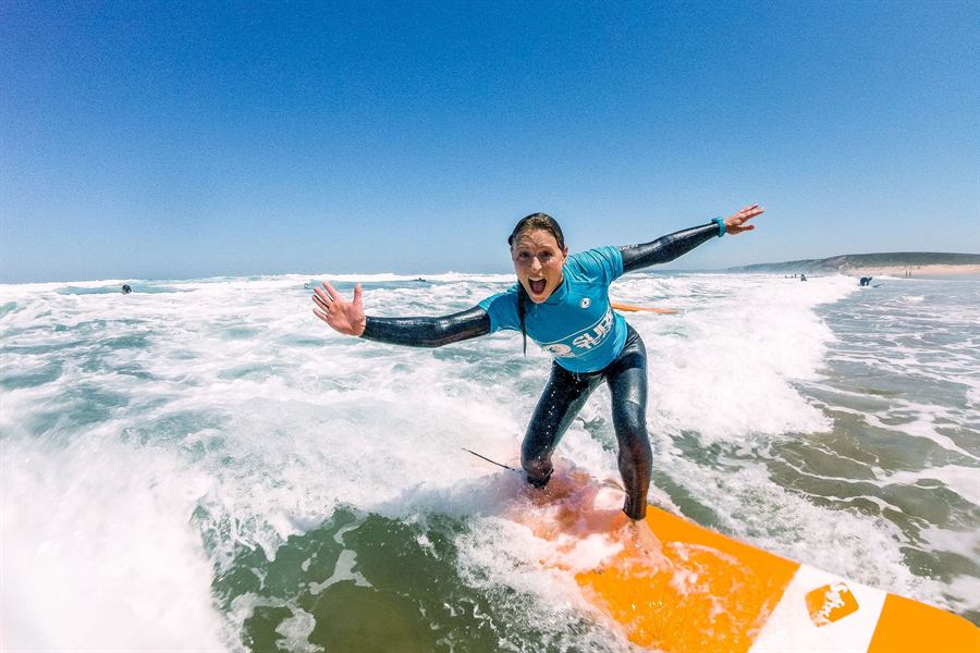 Surferin auf einer Welle an der Algarve
